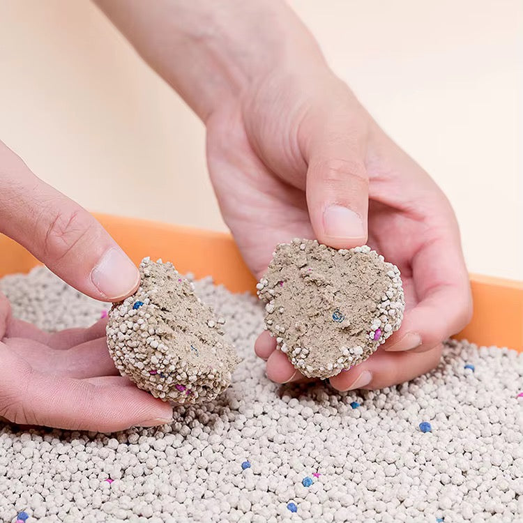 Hands holding the fine granules of unscented bentonite cat litter